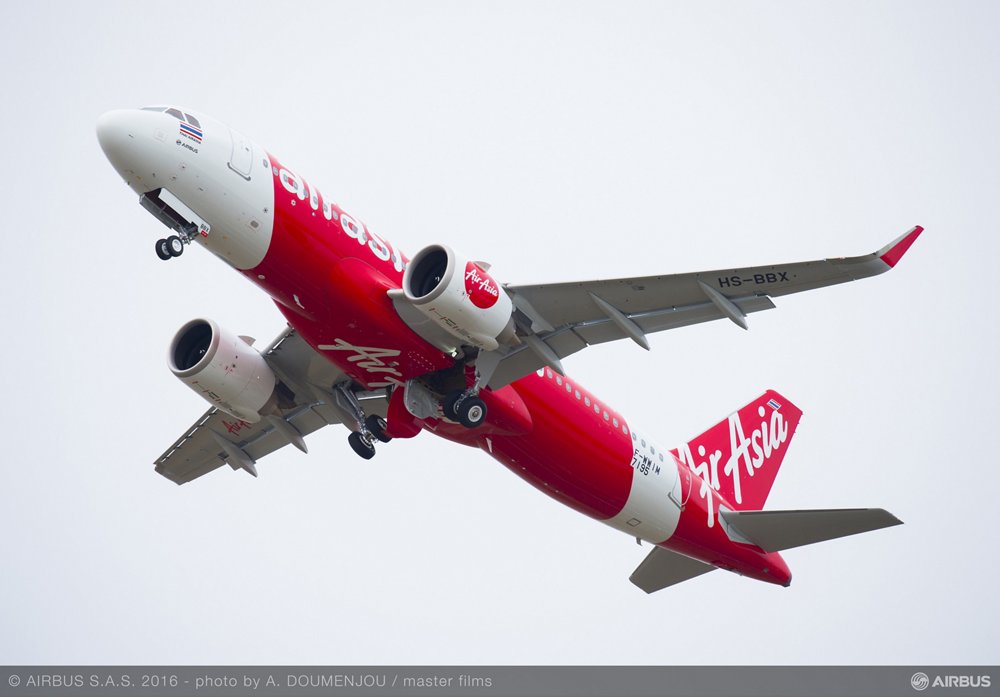 An Airbus A320neo in the livery of Thai AirAsia is shown during takeoff. 