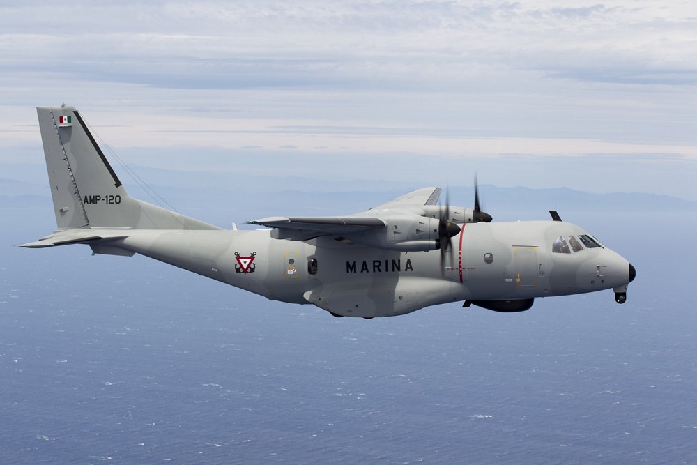 An in-flight C295W transport aircraft operated by the Mexican Navy flies over water. 