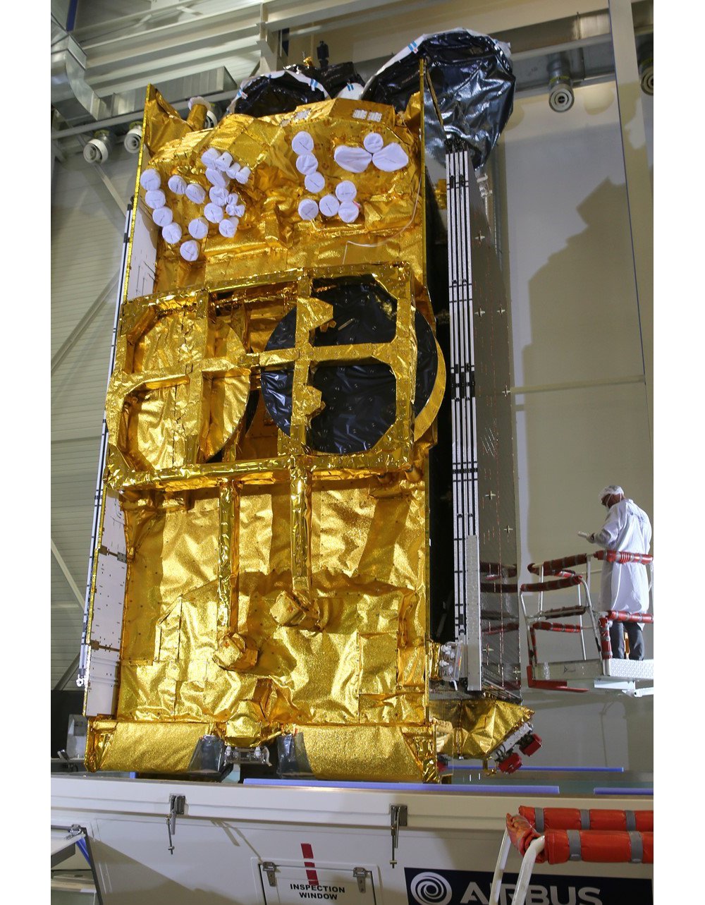 The Airbus-produced SKY Brasil-1 telecommunications satellite is evaluated in a clean room setting. 
