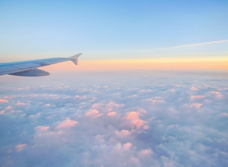 Wing of an airplane flying above the clouds
