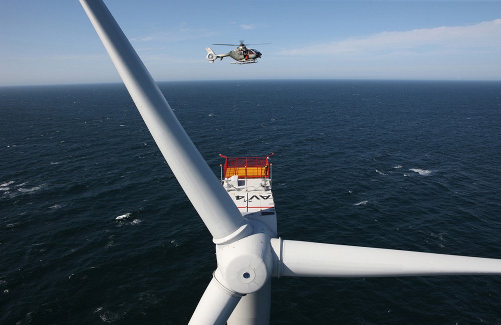背景中是一架空中客车H135直升机，背景中是一架水上风力涡轮机的特写镜头。乐动体育app靠谱吗