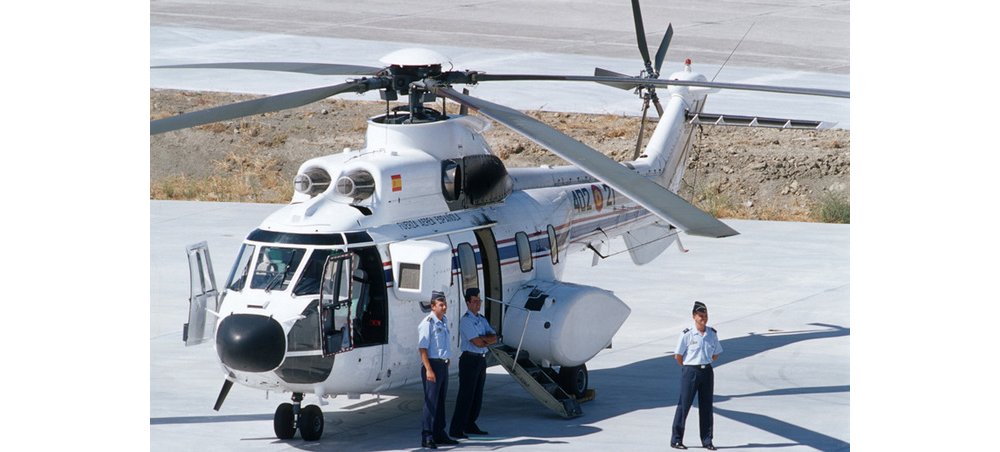 An Airbus H215 helicopter configured for passenger transport is shown parked on a helipad.