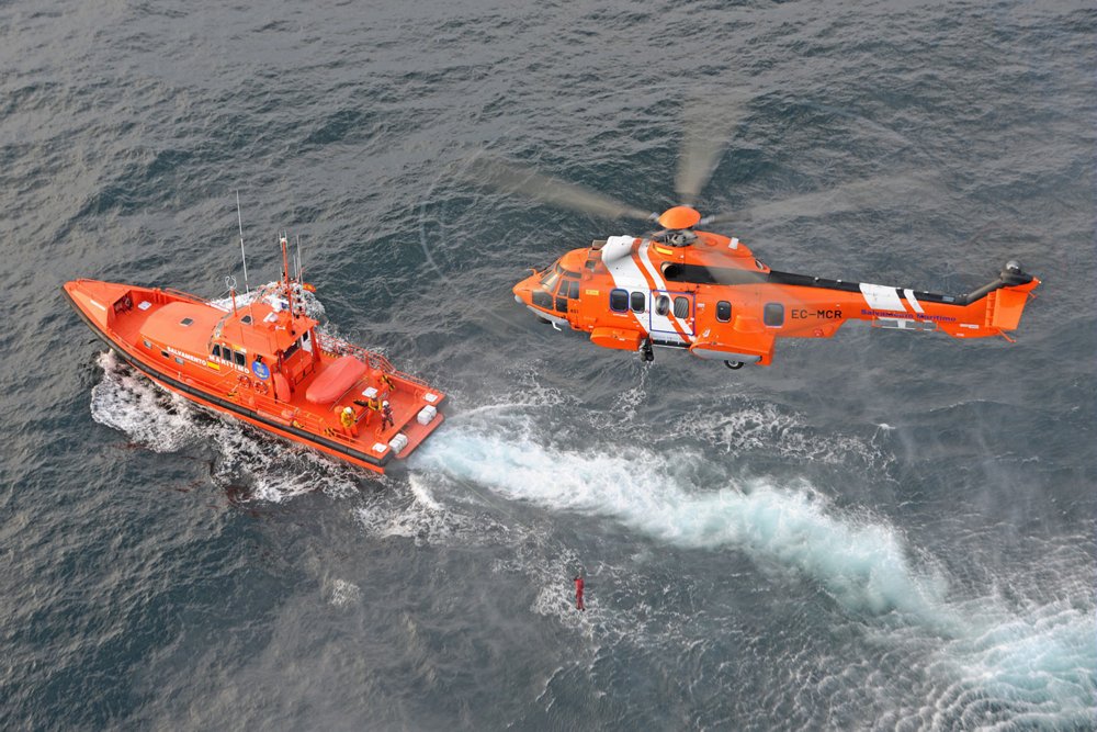 An aerial photo of an in-flight Airbus H225 helicopter configured for search and rescue (SAR) operations. 