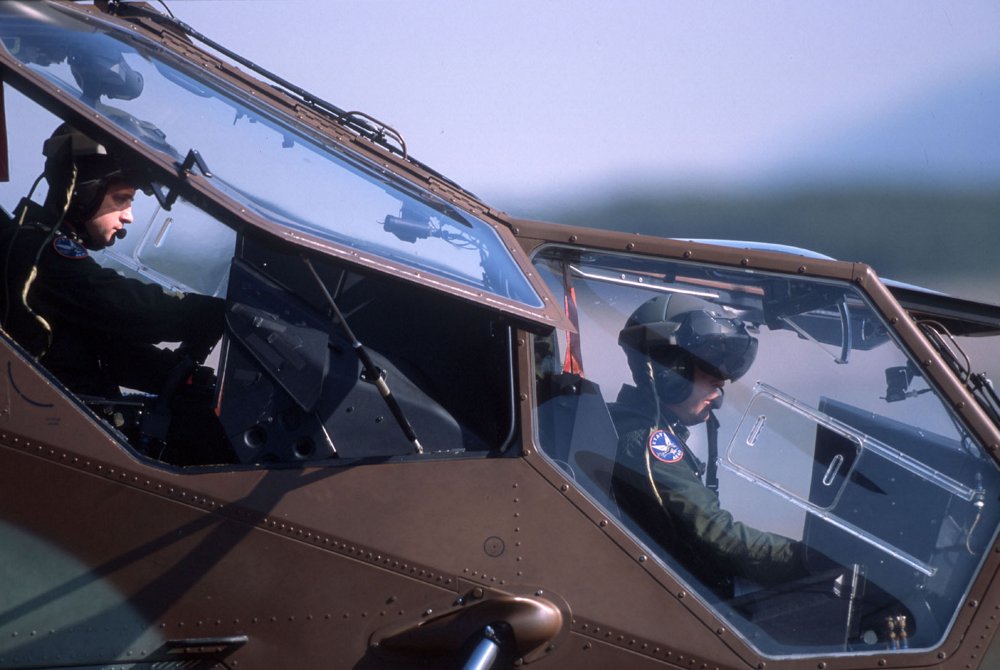 A side view of an Airbus Tiger HAD multi-role attack helicopter’s tandem-seat glass cockpit with two pilots inside. 