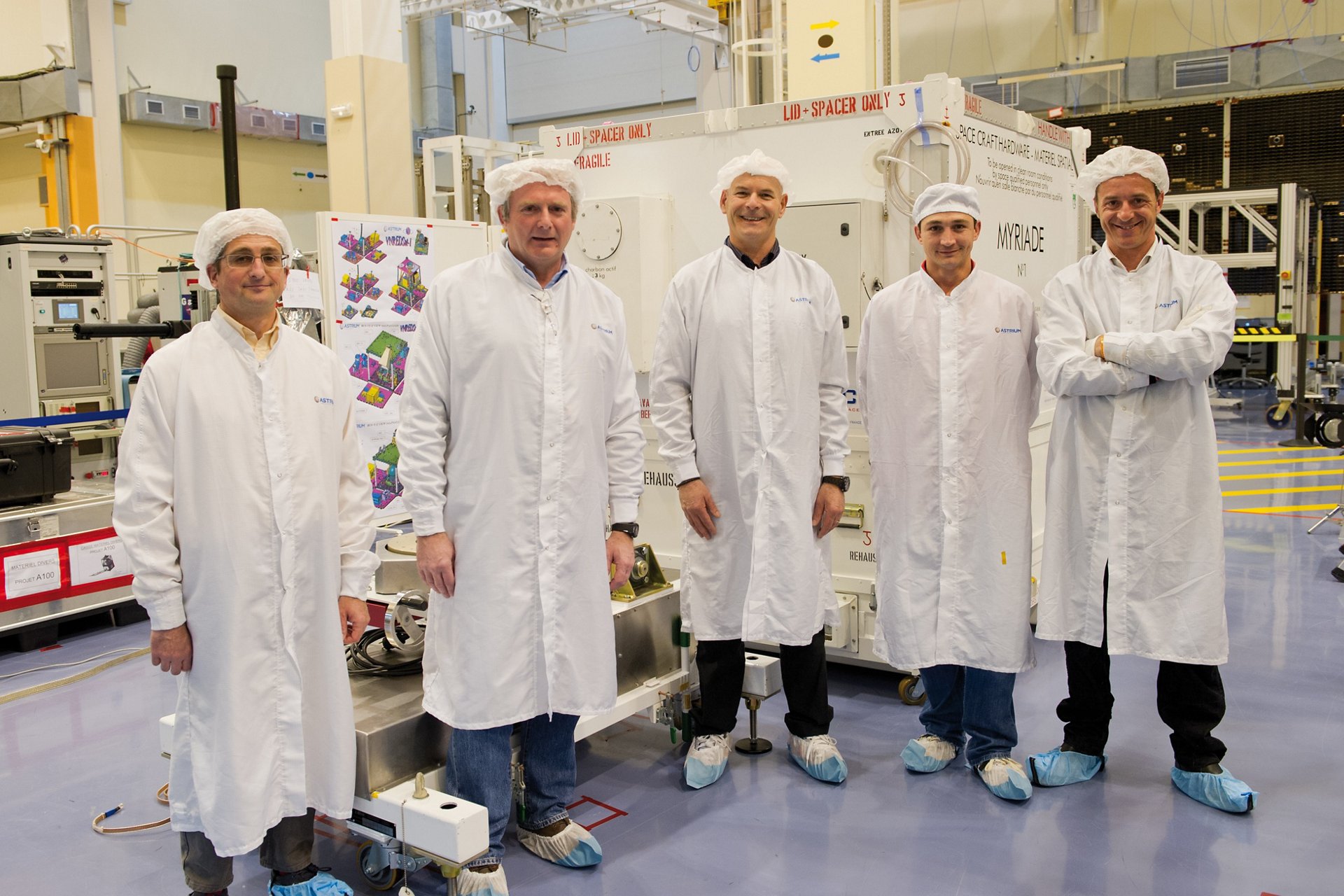 A group of Airbus satellite engineers inside a clean room facility.  