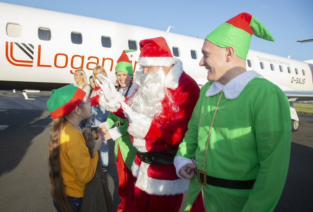 Girl with Santa in front of a plane