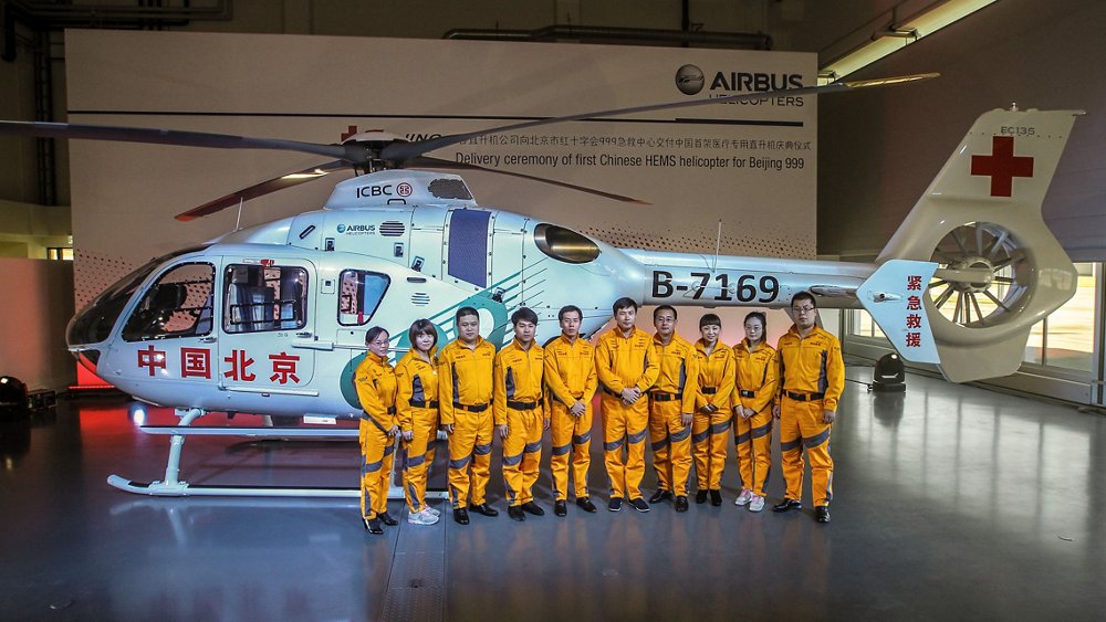 Chinese emergency medical service workers stand in front of an Airbus H135 helicopter. 