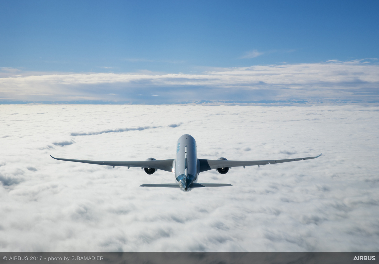 A rear view of an Airbus A330 Family aircraft flying above the clouds