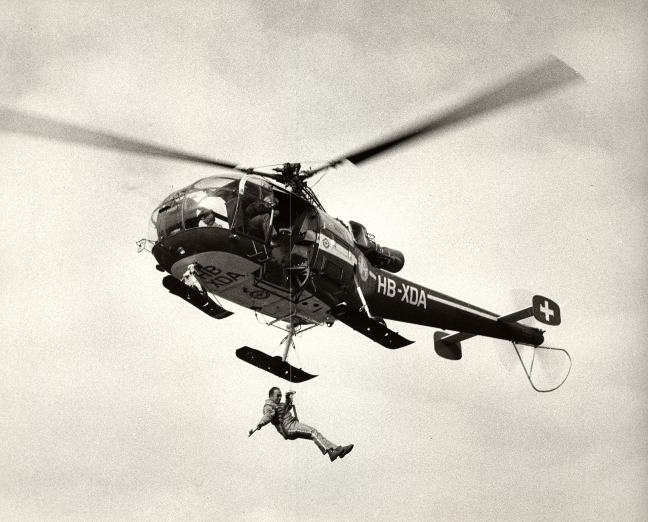 In-flight view of an Alouette III helicopter during a human airlift operation.
