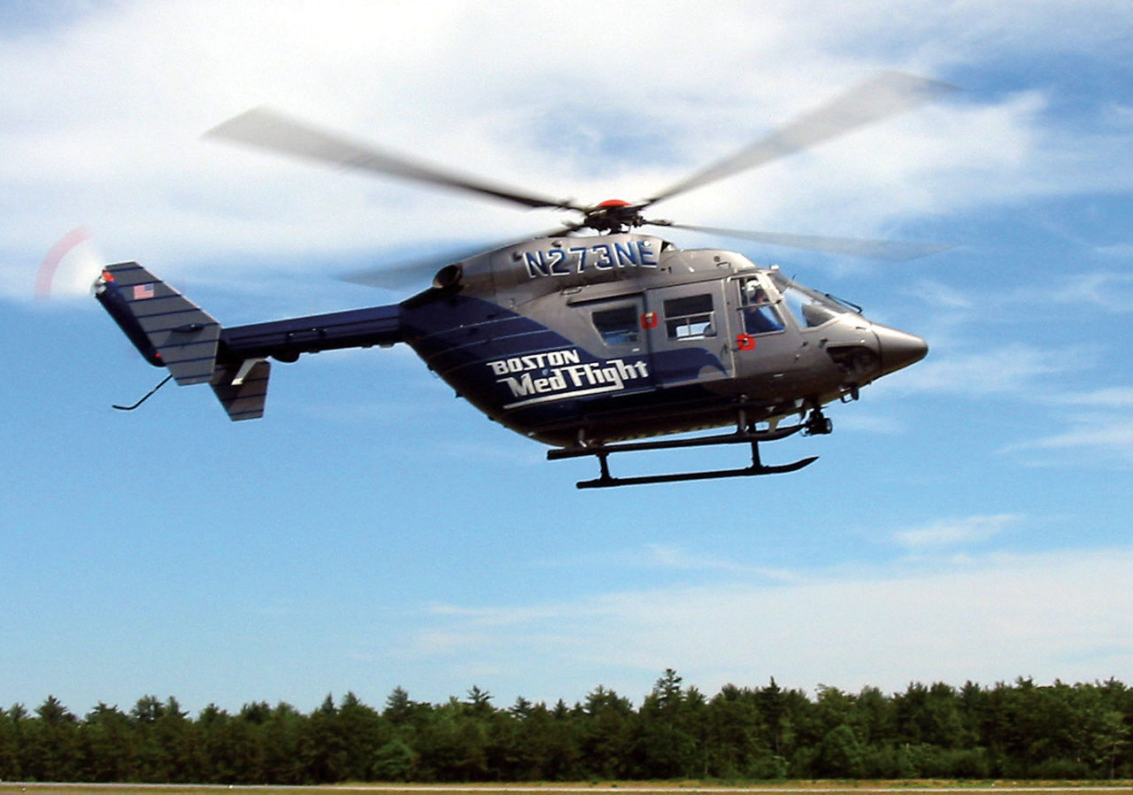 A view of an in-flight BK117 in the livery of Helicopter Emergency Medical Services (HEMS) provider Boston MedFlight.