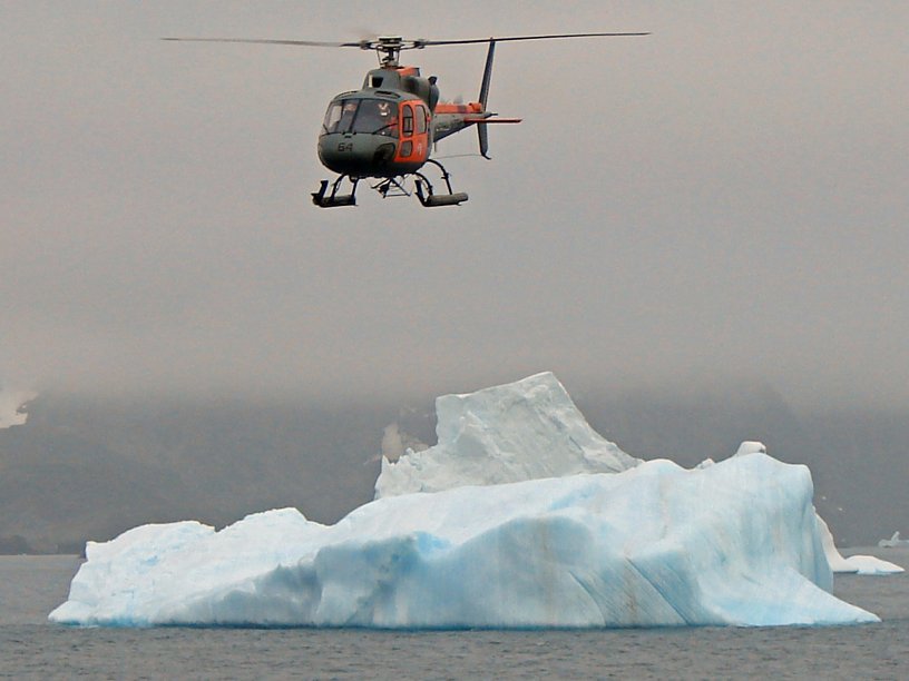 H125 flying above glacier