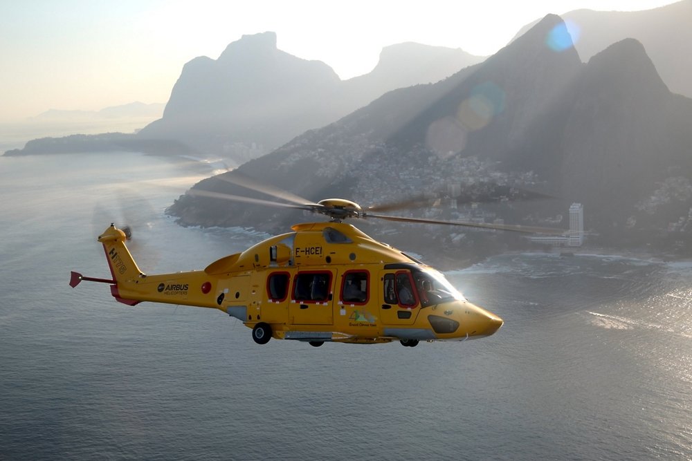 An EC175 helicopter (later re-designated H175) flies in a coastal area.  