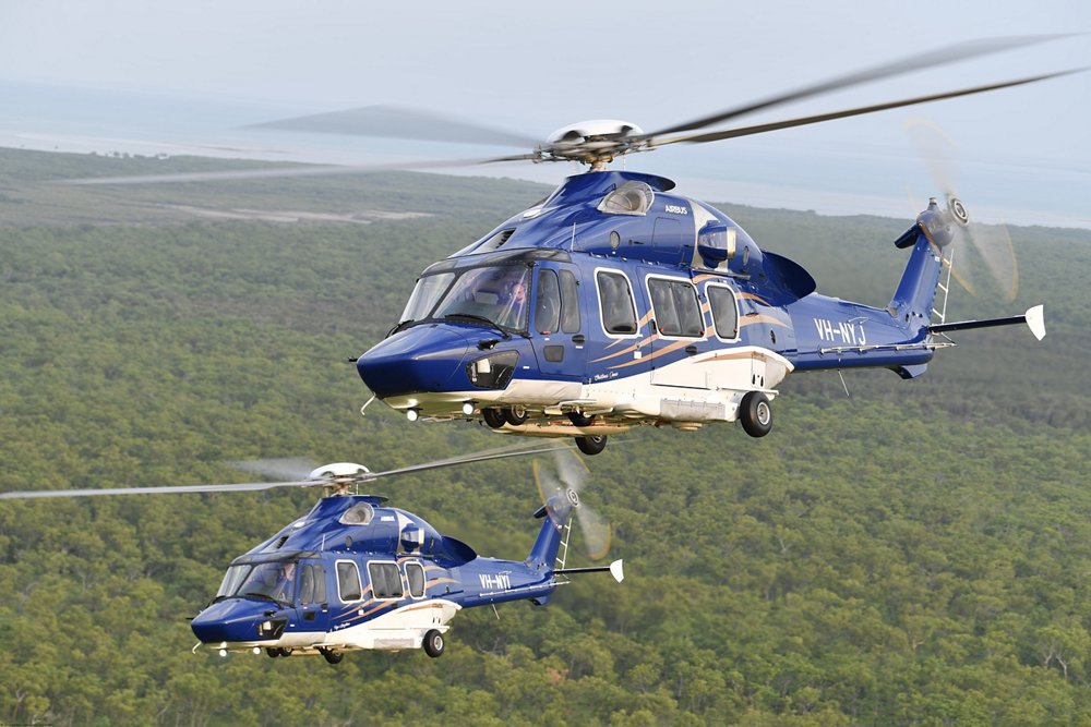 An Airbus H175 helicopter is shown flying over water. 