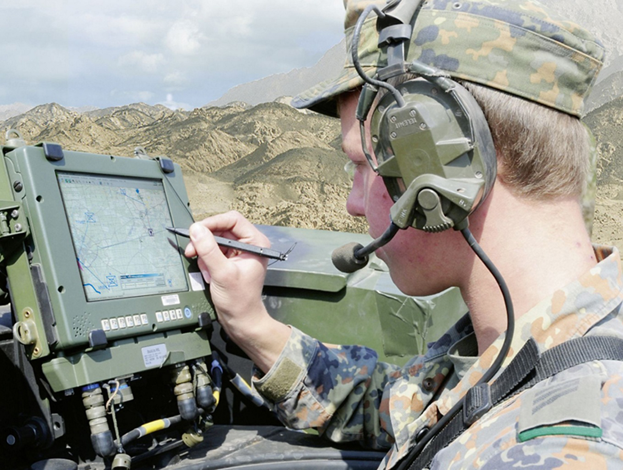 A member of the military uses a tablet device and stylus for mission planning.
