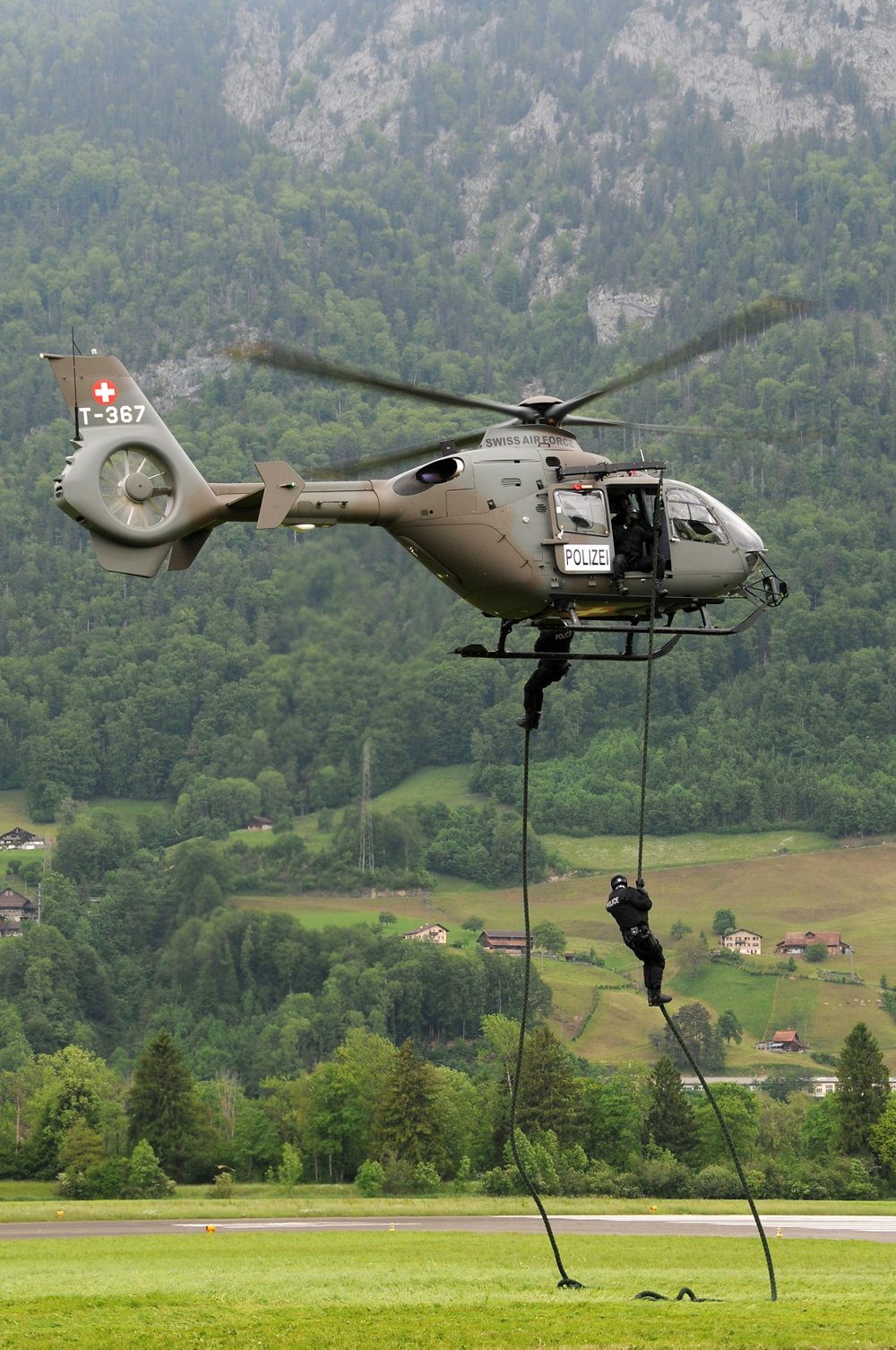 Police officers rappel from a Swiss Air Force H145 law enforcement helicopter. 