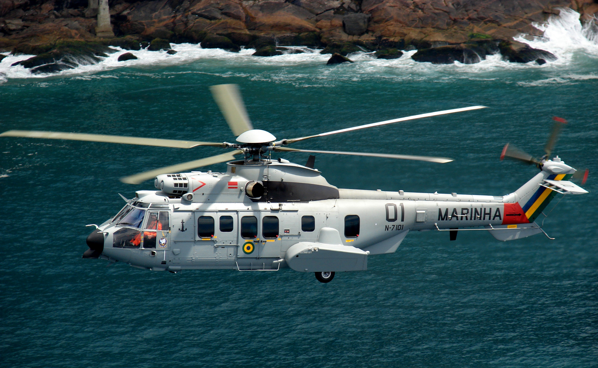 An H225M rotorcraft is showing flying over a coastal area. 