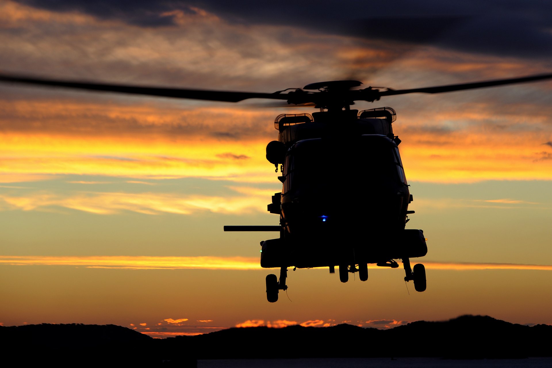 Front view of a NH90 NFH flying over the sea at the susnset