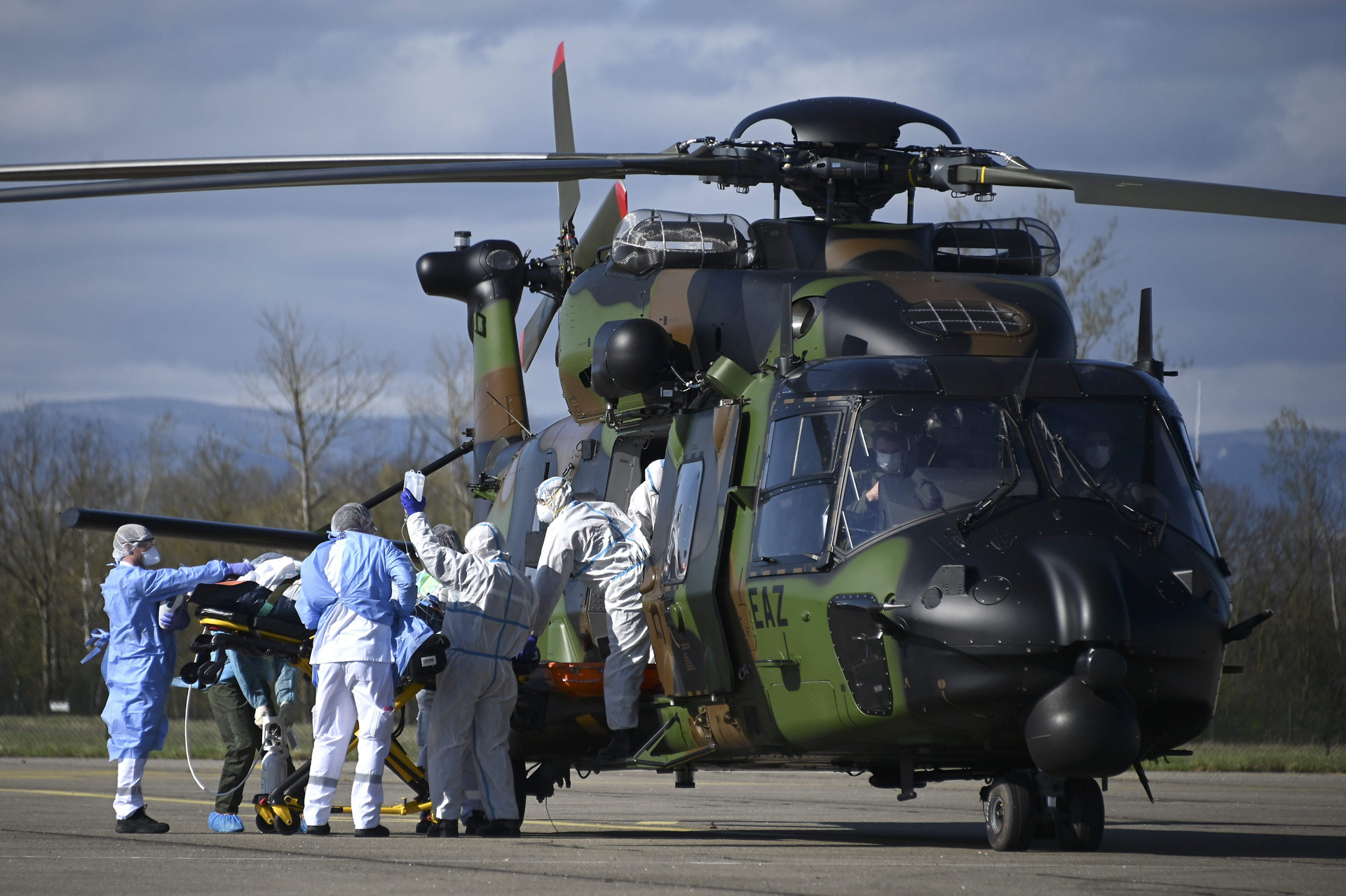 Medical staff push a Covid-19 patient on a stretcher towards the 1st Combat Helicopter Regiment's (RHC) NH90 in Strasbourg, on March 30, 2020.