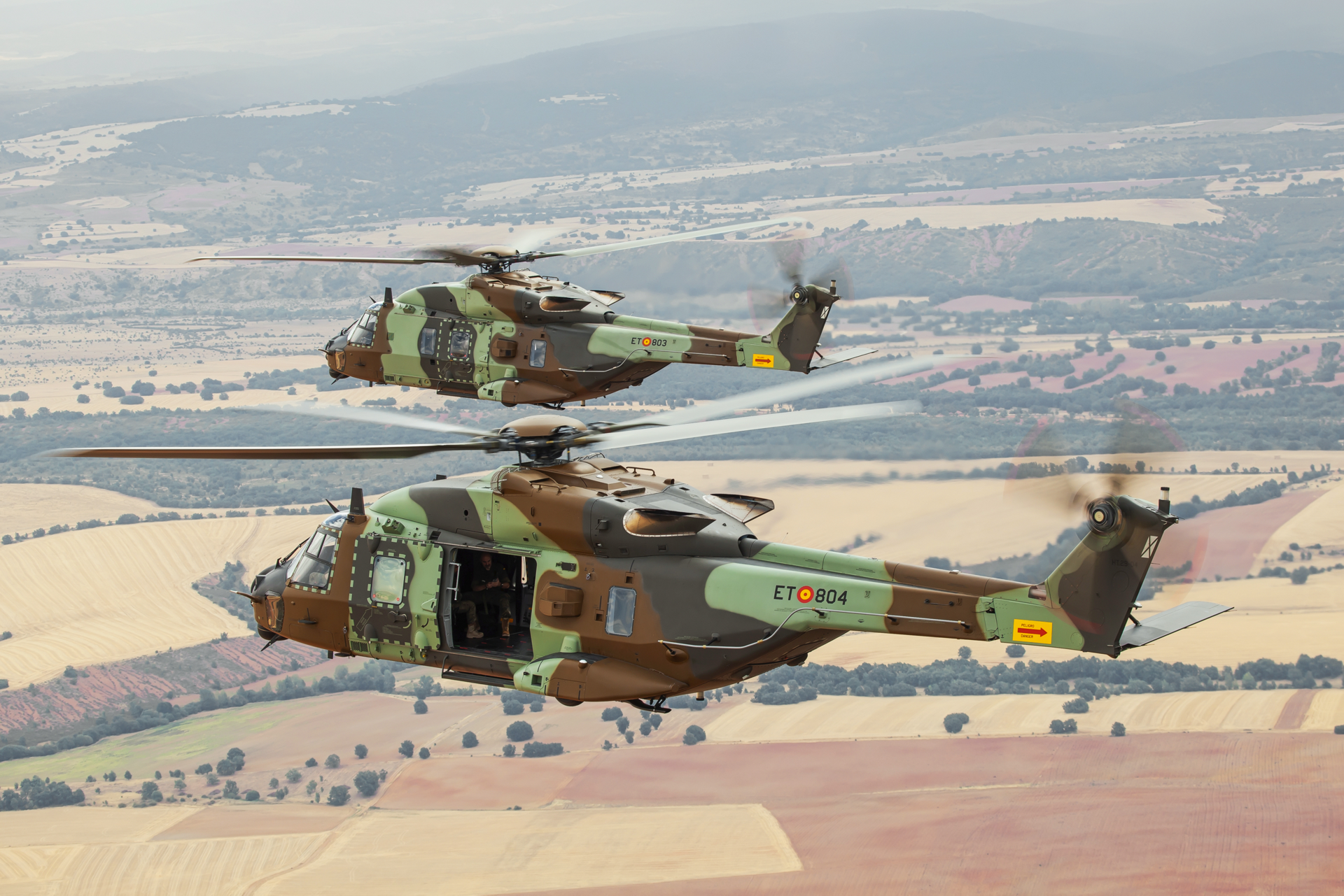 Two Spanish NH90s in the Standard 2 configuration are shown in flight.