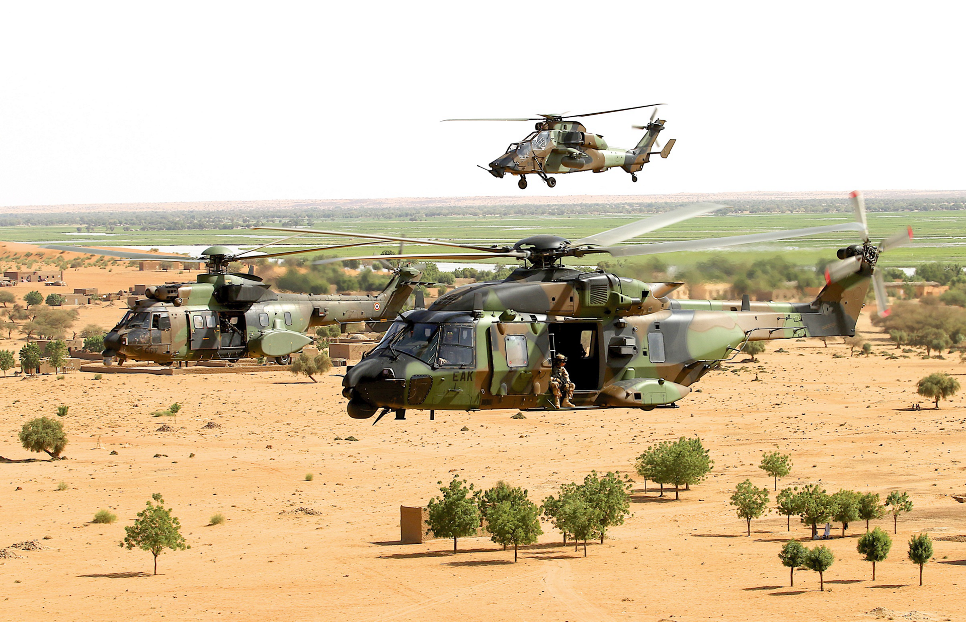 An NH90 and a Tiger helicopter fly in formation. 