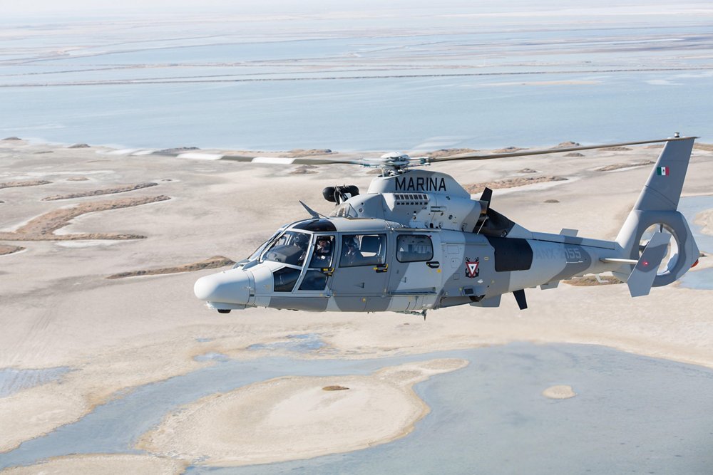 Side view of an in-flight Airbus AS565 MBe military helicopter. 