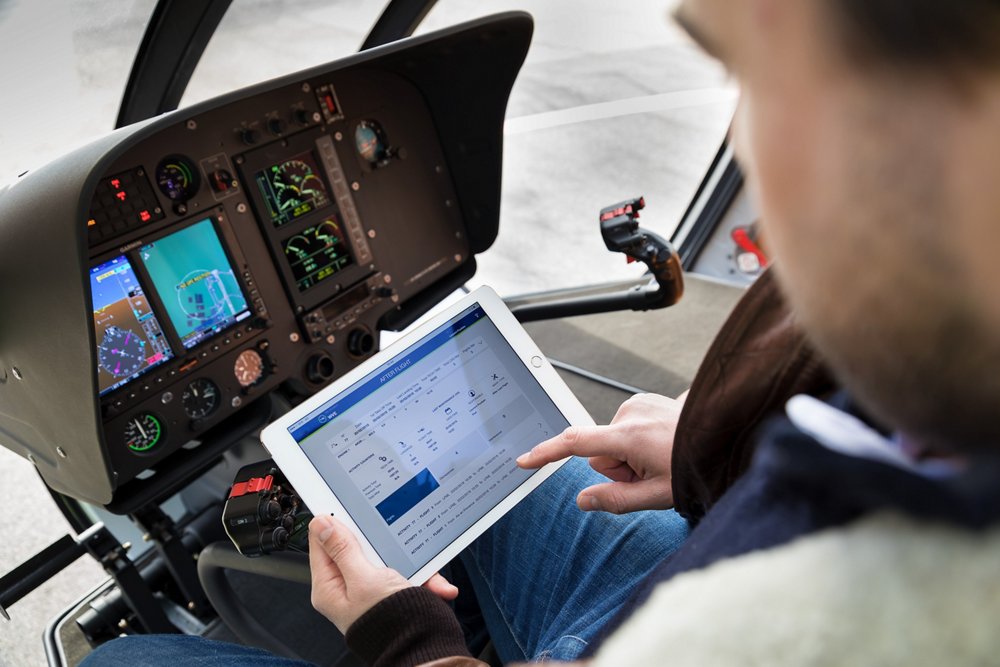 一名直升机飞行员在平板电脑上查看空中客车的飞行数据。乐动体育app靠谱吗