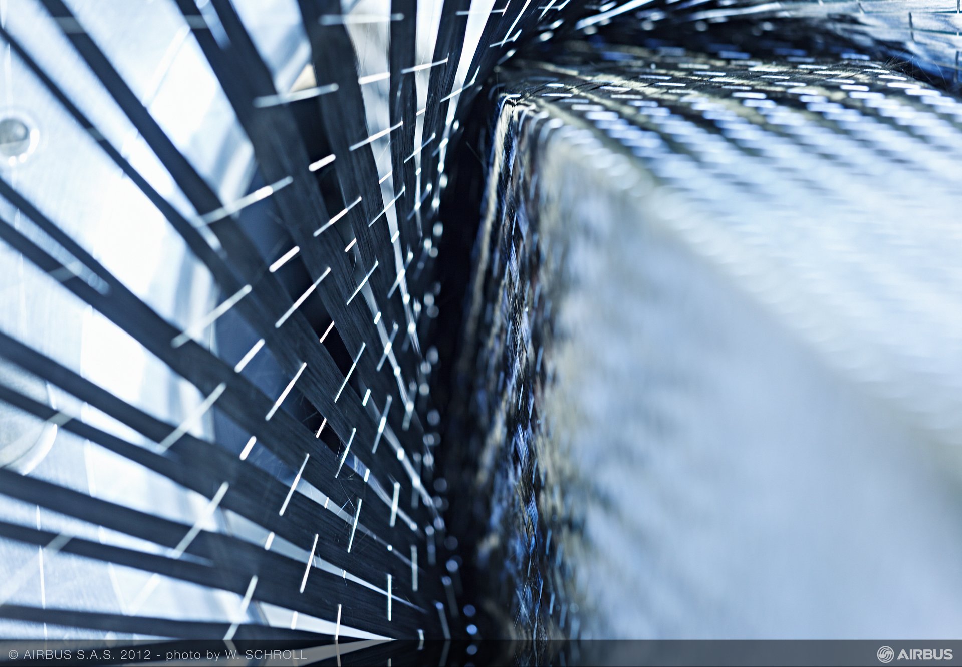 Utilised extensively in the Airbus A350 XWB aircraft family, carbon-fibre reinforced plastic is lighter than aluminium, stronger than iron, and more corrosion-resistant than both. Here, a component is fed through a high tech loom that braids the carbon fibres into place.
