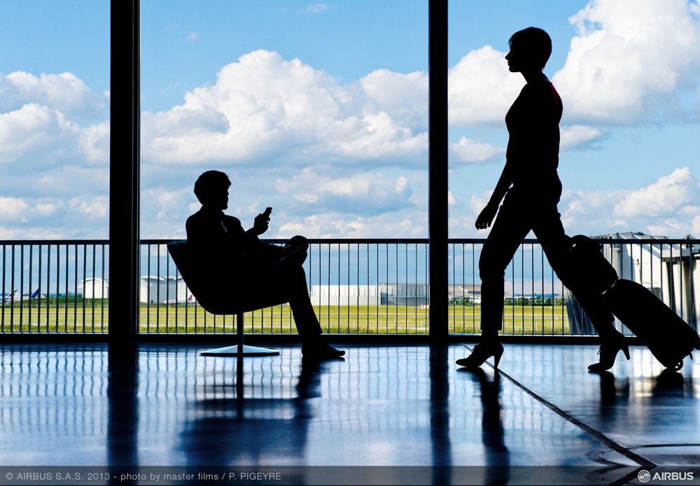 The silhouettes of two travellers at an airport facility 